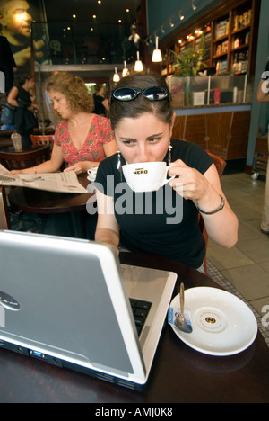 Young woman browsing the Internet on a laptop computer in a Caffe Nero, London, England, UK Stock Photo