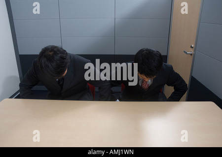 Two businessmen bowing Stock Photo