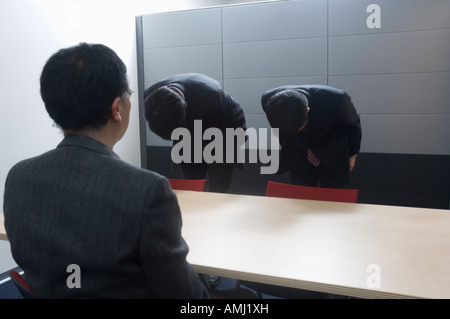 Two businessmen bowing Stock Photo