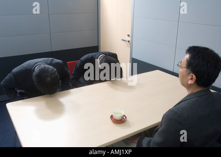 Two businessmen bowing Stock Photo