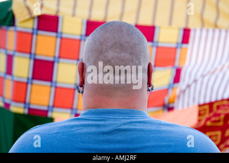 Back of the head of a big man with a skinhead against a colourful backdrop Stock Photo
