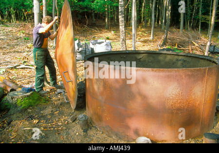Charcoal burning in the lake district using large steel kilns at Kendal Cumbria. Stock Photo