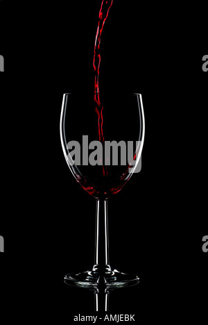 Low key shot of red wine being poured into a glass against a black background Stock Photo