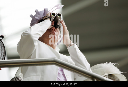 Woman looking through binoculars at Royal Ascot horse race, York, Great Britain Stock Photo