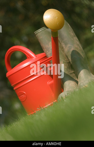 a stock photograph of wellington boots and a watering can in a garden ...