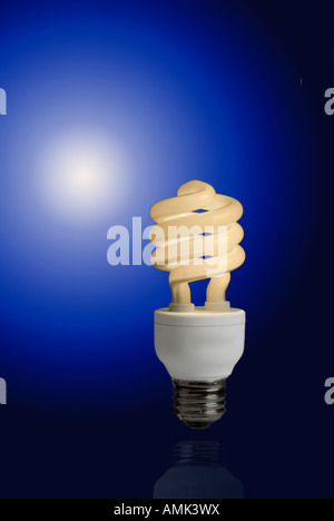 A new compact fluorescent light bulb against a deep blue gradient, these light bulbs save money and energy Stock Photo