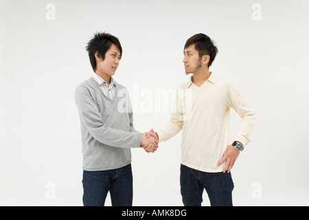Two young men shaking hands Stock Photo