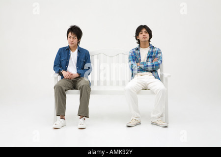 Two young men sitting on bench Stock Photo