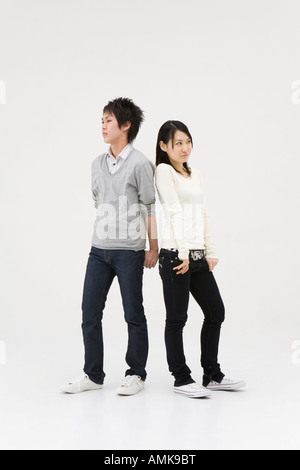 Young couple standing back to back Stock Photo