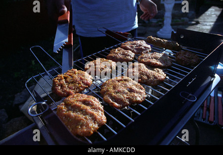 A man cooking hand made burgers on a barbecue in Leicester England UK Stock Photo