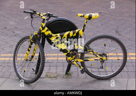 A mountain bike wrapped up in black and yellow tape Stock Photo