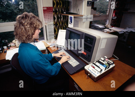 Woman typing on early computer Stock Photo