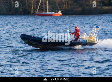 A Warden Driving a Fast Patrol Boat on Lake Windermere Lake District National Park Cumbria England United Kingdom Stock Photo