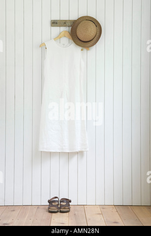 Linen dress hanging on wall Stock Photo
