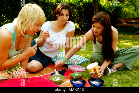 Young women in a garden eating ice cream Stock Photo