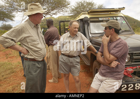 Cinematographer of Out of Africa speaks with John Taft and Humane Society CEO Wayne Pacelle in Tsavo National Park Kenya Africa Stock Photo