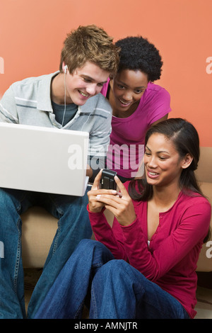 Group of Teens Using Laptop, and Cellular Phone Stock Photo