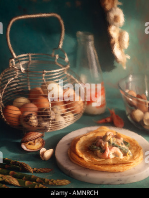 Seafood pancakes or French crepes being prepared in a blue kitchen setting with a basket of eggs behind, shot with paint effect Stock Photo