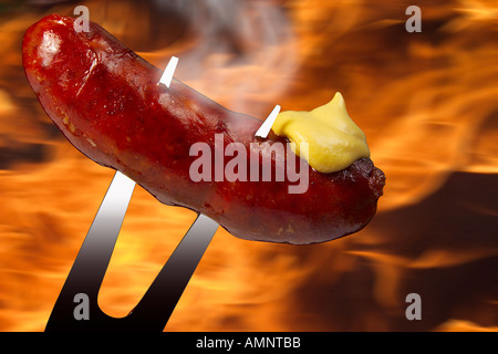 Roast sausage with mustard on fork Stock Photo