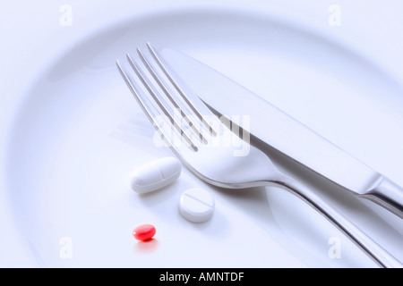 Pills and cutlery on plate Stock Photo