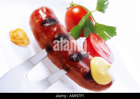 Roast sausage with mustard on fork Stock Photo