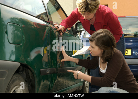 Car driver looking at the damage to her car with another driver after a road car accident in France - car insurance concept Stock Photo