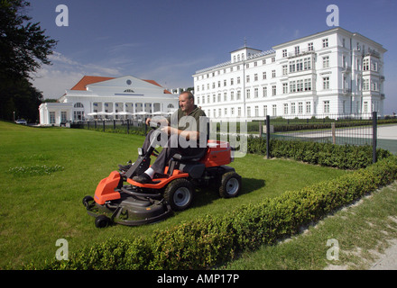 Man mowing the lawn in front of the Kempinski Grand Hotel in Heiligendamm, Germany Stock Photo