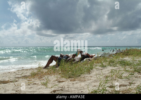 Couple sunbathing on Accra beach Christ Church Barbados Stock Photo