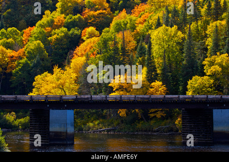 Bridge across Riviere Jacques-Cartier, Jacques Cartier River, surrounded by fall colours in Parc de la Jacques-Cartier,Canada. Stock Photo