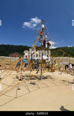 Boys and girls playing on rope climbing frame, Children on playground Stock Photo