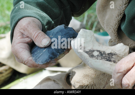 Flint knapper at work on a tool with an antler as the hammer. Stock Photo