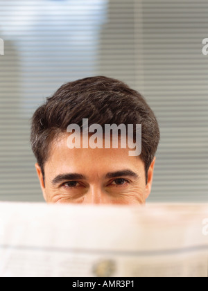 Man Looking Over Newspaper Stock Photo