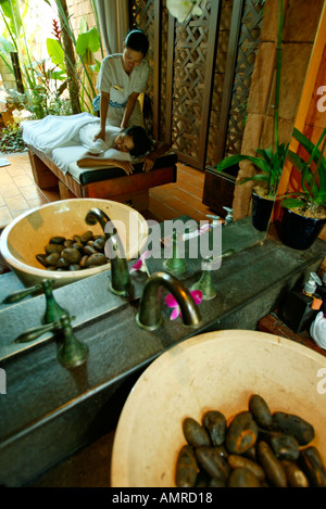 Thai massage a female masseuse massages the thighs of a young male