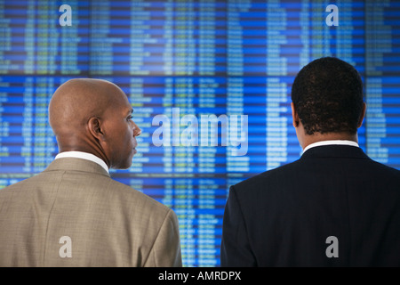 African businessmen in front of Arrival Departure board Stock Photo