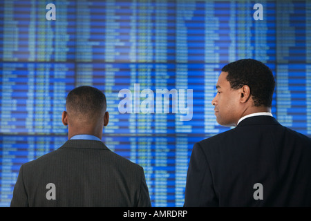 African businessmen in front of Arrival Departure board Stock Photo