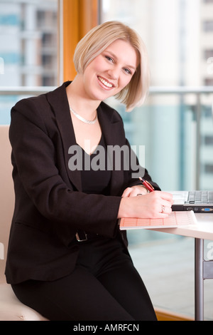 smiling businesswomen writing in a calendar Stock Photo