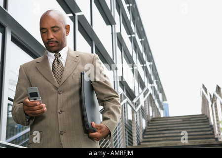 African businessman looking at cell phone Stock Photo