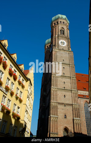 High towers of the church Frauenkirche with a residental house Munich Bavaria Germany Stock Photo