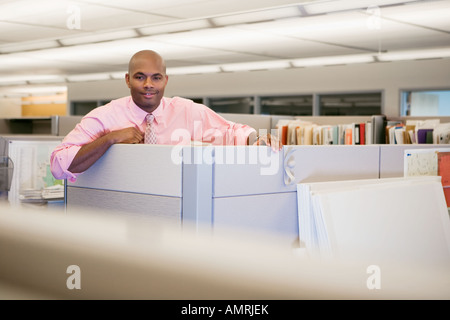 African businessman leaning on cubicle wall Stock Photo