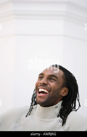 Young black man with dreadlocks laughing while holding his head ...