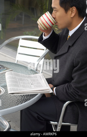 Man Drinking Coffee At Cafe Table Stock Photo