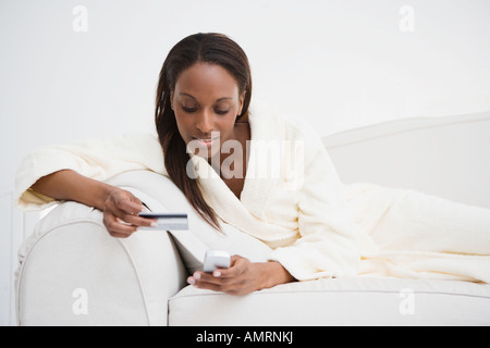 African woman with credit card dialing cell phone Stock Photo - Alamy