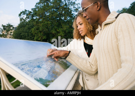African couple looking at tourist information board Stock Photo