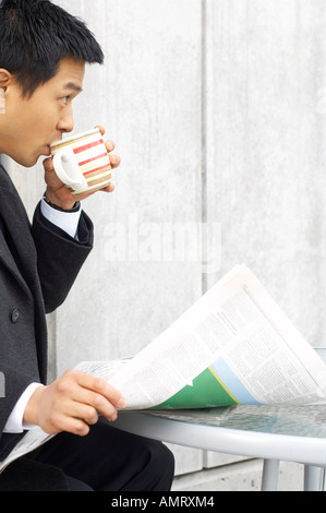 Businessman Drinking Coffee and Holding Newspaper Stock Photo