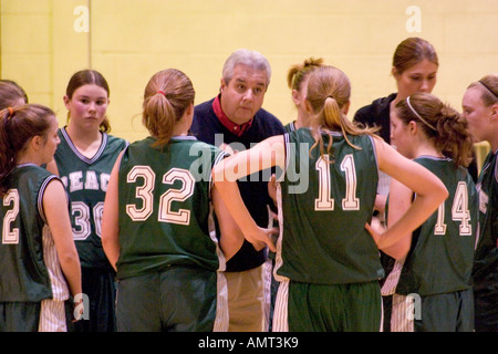 Coach instructing girls basketball team during time out age 14 and 56. Downers Grove Illinois IL USA Stock Photo