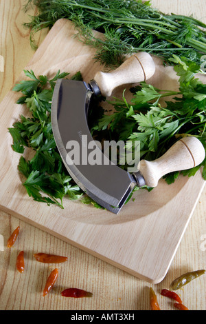 Freshly chopped green coriander on a light wood chopping board with a  mezzaluna herb chopper Stock Photo - Alamy