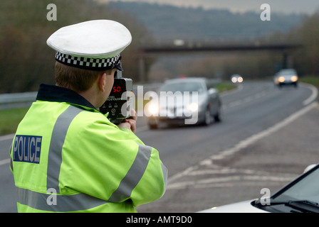 British traffic Police Officer monitors the speed of road traffic using a radar gun Stock Photo