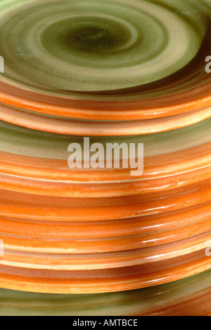 handmade rustic ceramic plates stacked in a cupboard Stock Photo