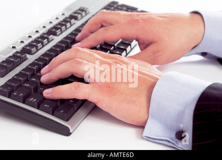 Mans hands operating a computer keyboard Stock Photo