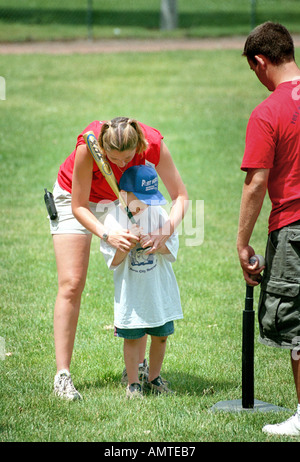 4 and 5 year old boys and girls learn how to hit a ball off of a tee Stock Photo